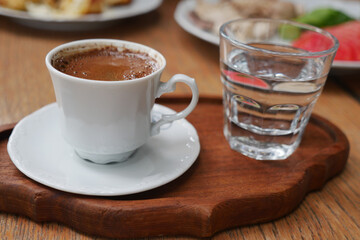  turkish coffee and clear water served on wooden tray in cafe