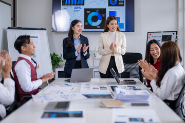 Business team clapping hands after successful presentation in meeting room