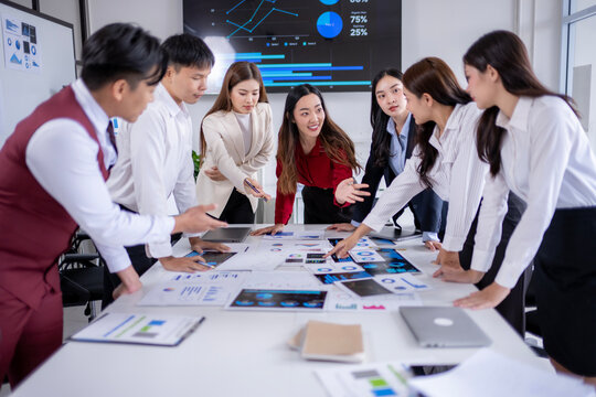 Business team analyzing data on printed reports and digital tablets in office meeting