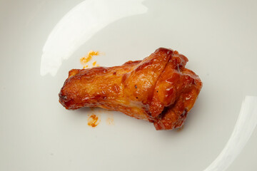 Grilled spicy chicken wing on white plate