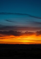 Obraz premium Colorful Sunset Sky Over Landscape with Vibrant Orange and Blue Clouds