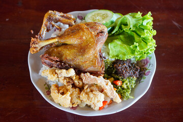 Fried Duck with Black Spices, captured on October 9, 2025. Crispy duck richly seasoned with aromatic black spices, paired with spicy green chili sambal and fresh sambal matah, authentic Indonesian cul