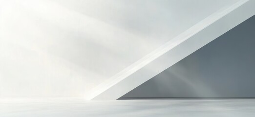 Minimalist empty interior space with white and gray angled walls and sunlight casting soft shadows on the floor
