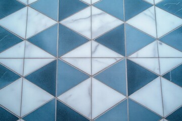 Close-up of geometric patterned tiles with blue and white triangular shapes creating a repeating diamond design with subtle marble texture