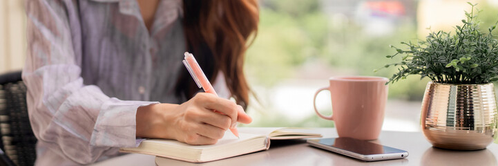 Asian adult woman hand writing notes planning ideas productive work cozy home office desk personal...