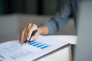 Close-Up of Businessman Working on Laptop with Business Report Graphs at Office.
