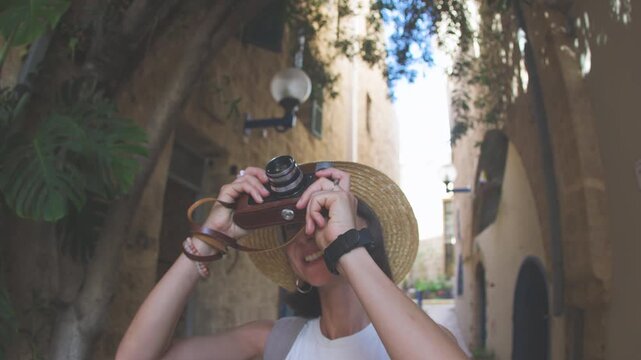 A girl walks around the city and photographs landmarks. A girl travels and shoots content for her blog. A tourist with a camera.
