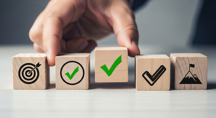Hand putting wooden cube block with goal, check mark, and target icon for business strategy and action plan concept
