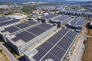 Aerial view of industrial buildings with solar panels on roofs © zhouyilu