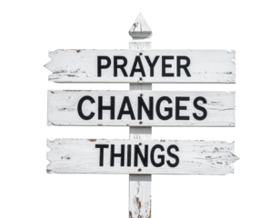 A weathered wooden sign displays the inspirational message: "Prayer Changes Things," emphasizing the power of prayer in life.