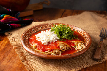 Entomatadas. Also known as Enjitomatadas, a typical dish of Mexican cuisine prepared with corn tortilla, tomato sauce and stuffed with shredded chicken meat. Classic homemade recipe.