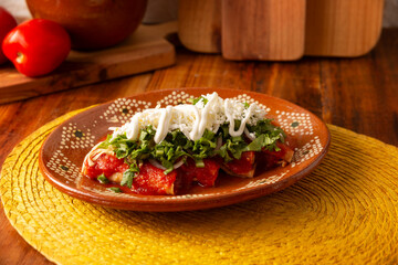 Entomatadas. Also known as Enjitomatadas, a typical dish of Mexican cuisine prepared with corn tortilla, tomato sauce and stuffed with shredded chicken meat. Classic homemade recipe.