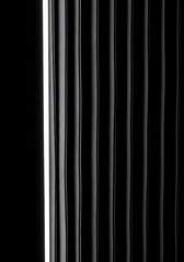 Obraz premium Monochrome abstract background of vertical glossy black stripes with dramatic highlights and shadows.