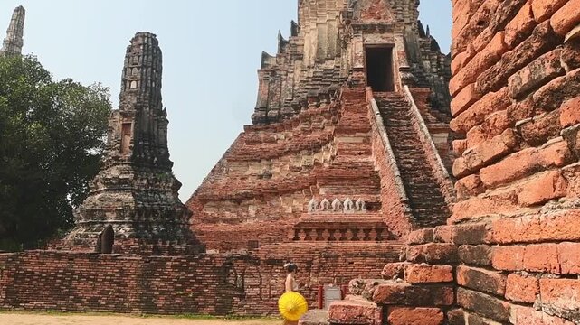 Thailand, Ayutthaya - march 15th, 2023: Woman in traditional Thai dress walk sightseeing visit ancient Buddha statue.Ayutthaya historical park. UNESCO World Heritage Site