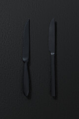 Table knives on dark background