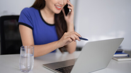 Adult Asian businesswoman remotely communicate laptop computer desk pen relaxed smile professional...