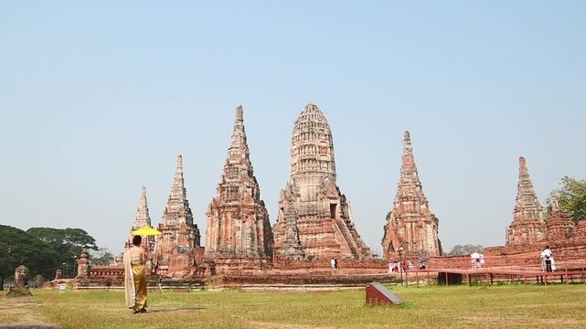 Thailand, Ayutthaya - march 15th, 2023: Woman in traditional Thai dress pose sightseeing visit ancient Buddha statue.Ayutthaya historical park. UNESCO World Heritage Site