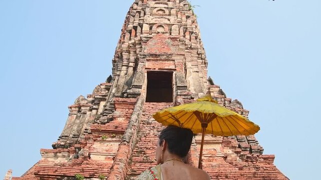 Thailand, Ayutthaya - march 15th, 2023: Woman in traditional Thai dress pose sightseeing visit ancient Buddha statue.Ayutthaya historical park. UNESCO World Heritage Site