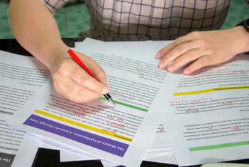 hand holding red pen to do proofreading