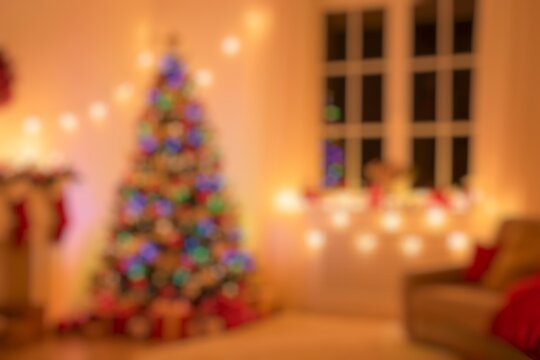 Blurred and warm atmosphere Xmas Home Interior Decoration, Hanging Sock and Present Toys. A cozy and soft armchair with nice pillows under a tall lamp near a magic christmas tree full of bright toys.