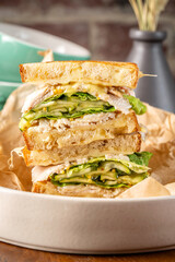 Chicken sandwich with melted cheese, cucumber, and lettuce