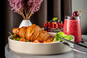 Croissant breakfast with berry smoothie