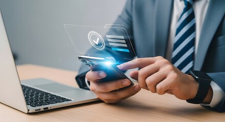 Businessman interacting with futuristic digital interface on smartphone next to laptop