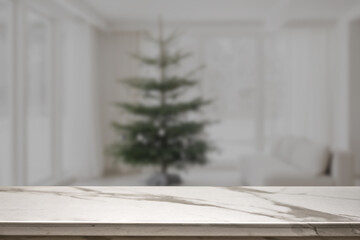 Marble table top on blur with bokeh christmas tree background