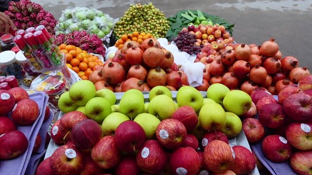 Various types of colorful fruits are arranged for sale in the market.