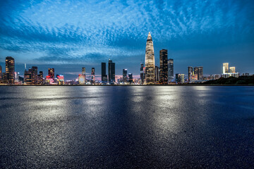 Empty asphalt road with the illuminated modern city skyline at night in Shenzhen, China.