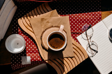 Morning sunlight illuminates pink coffee cup on windowsill with glasses and candle. Cozy and calm mood.