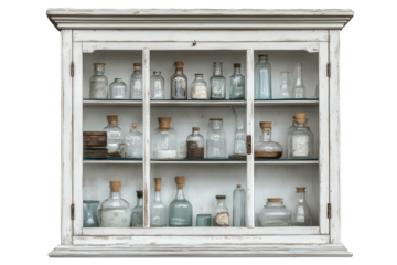 Distressed white apothecary cabinet filled with vintage glass jars in a rustic setting showcasing an array of old medicinal ingredients and herbs collected over time