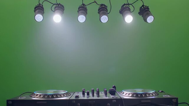 Professional D J turntable setup with illuminated platters and studio spotlights against a green screen background for easy compositing 4k animation video