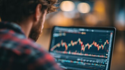 Close-up of a man monito financial trading charts on a digital screen with stock market data and candlestick graphs in a modern office environment