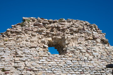 Stone wall on the hill against blue sky