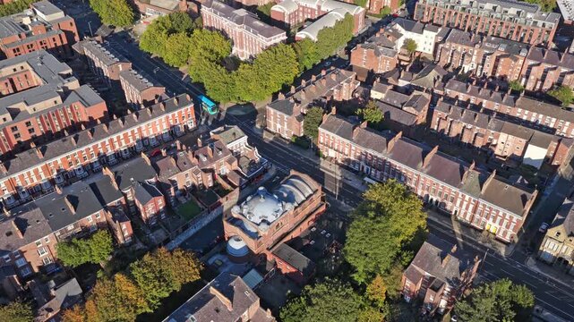 Aerial view of Liverpool&rsquo;s classic terraced homes shows rows of brick houses, tree-lined streets, and a central civic building, 19th-century planning and working-class architectural pride.