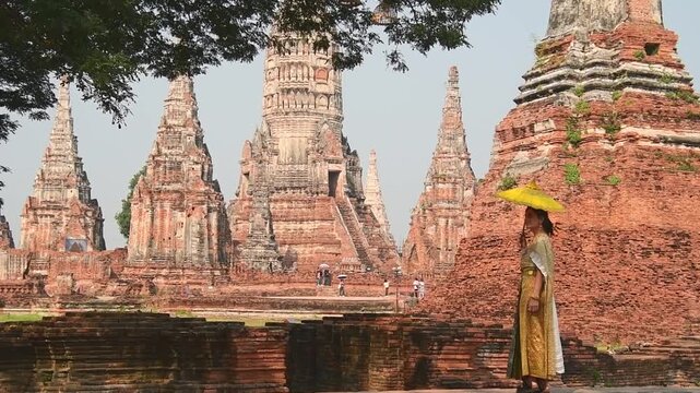 Thailand, Ayutthaya - march 15th, 2023: Woman in traditional Thai dress pose sightseeing visit ancient Buddha statue.Ayutthaya historical park. UNESCO World Heritage Site