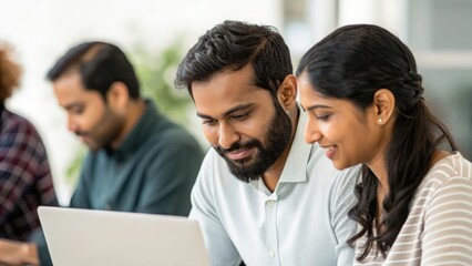 Indian coworkers collaborating at computer — representing teamwork, innovation, and communication