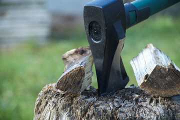 Axe splitting wood on a tree stump, ready for the fireplace or a campfire.