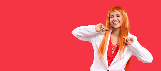 Beautiful young happy woman in orange wig on red background