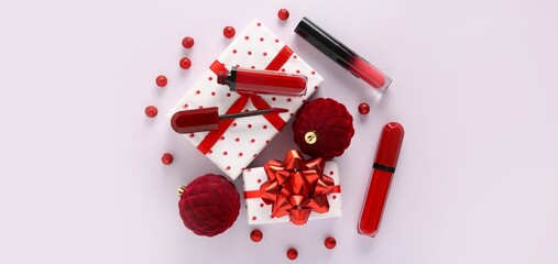 Composition with Christmas balls, lipsticks and gifts on light background