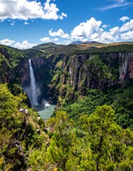 Scenic view of a cascading waterfall in a verdant, mountainous landscape
