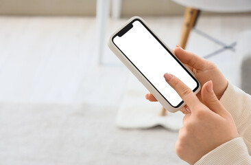 Young woman using mobile phone with blank screen in living room