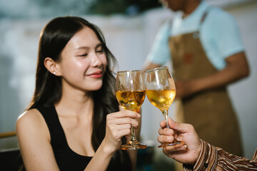 Two young women enjoying grilled food and wine together at an outdoor party, smiling and chatting in a relaxed, friendly atmosphere.