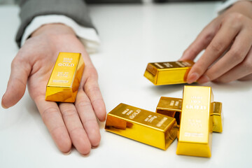 Asian woman holding gold bar in finance business.