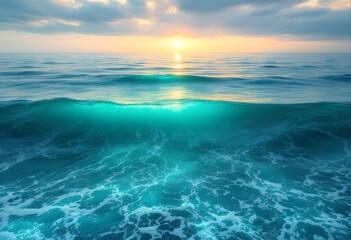Fototapeta premium A breathtaking view of a glowing turquoise wave in the deep blue ocean during a spectacular golden sunset over the water