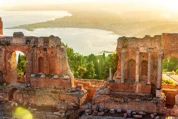 Panoramic view of a beautiful sunset in Ancient Theatre of Taormina in Sicily with antique italian...
