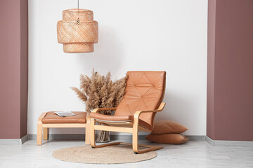 Stylish interior of living room with comfortable armchair and stool