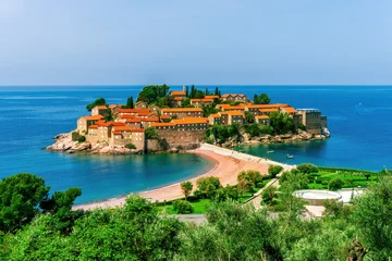Gardinen Insel picturesque seascape of beautiful isle Sveti Stefan near Budva Montenegro. Scenic orange buildings in Ardiatic sea with blue water and amazing sky on background of landscape  © Yaroslav