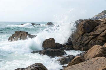 Obraz premium Large wave crashing into a rocky shore